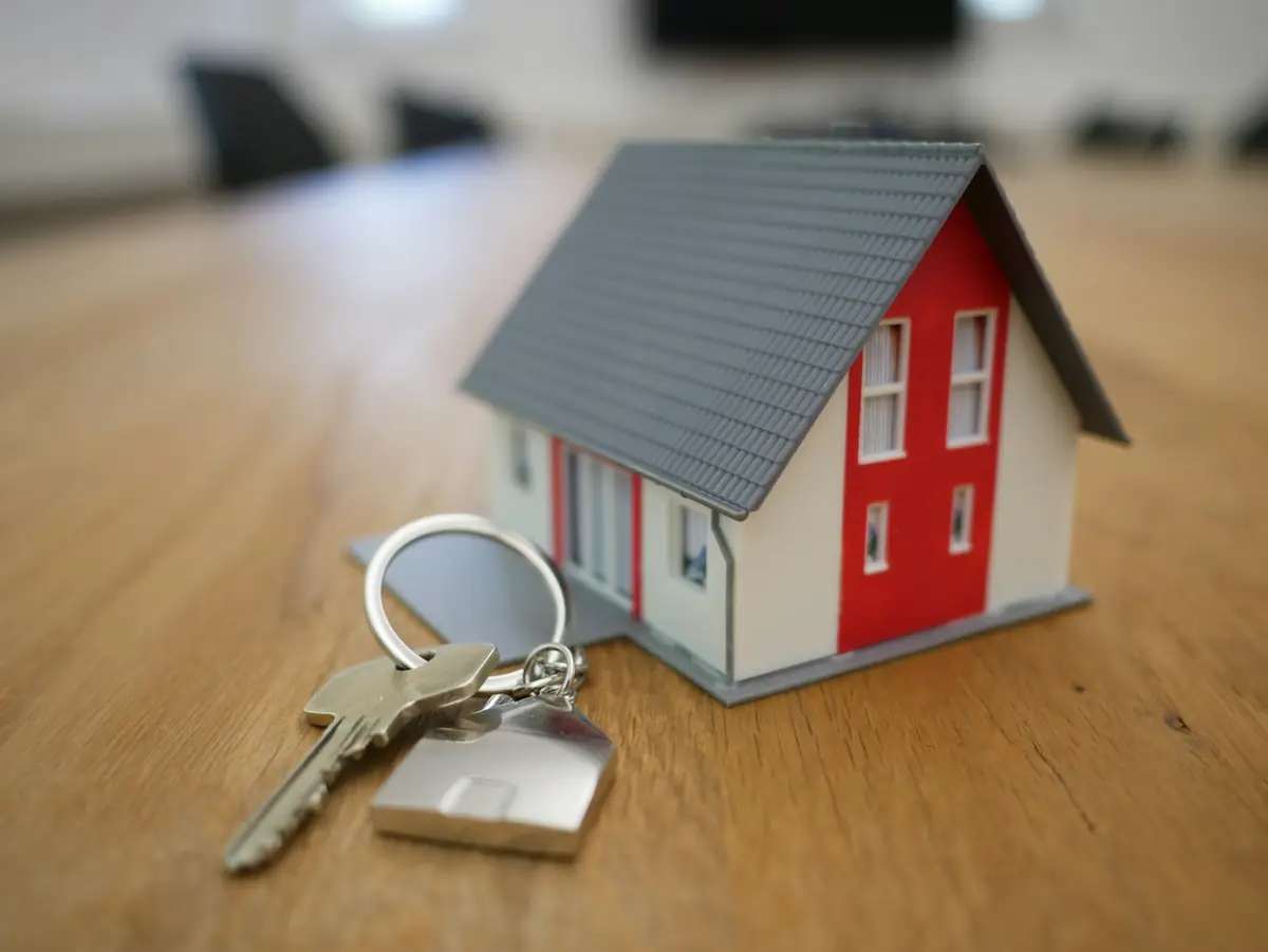 Maquette van een huis met sleutels, symbool voor verkoop of verhuur